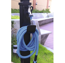 Zwarte tuinwatertap met zilverkleurige kraan en een opgerolde blauwe tuinslang aan een houder in de buitenlucht.