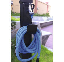 Watertappunt voor de tuin met flexibele tuinslang en waterkraan op een zwarte zuil.