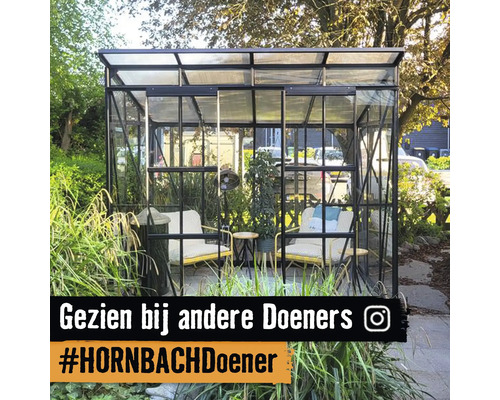 Een tuinkas in de tuin, ingericht als een gezellige zithoek met twee fauteuils en planten.