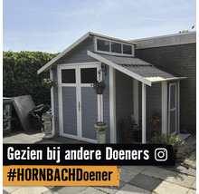 Grijs houten tuinhuis met witte details, dubbele deuren met ramen, zadeldak en aanbouw met afdak in een tuin.