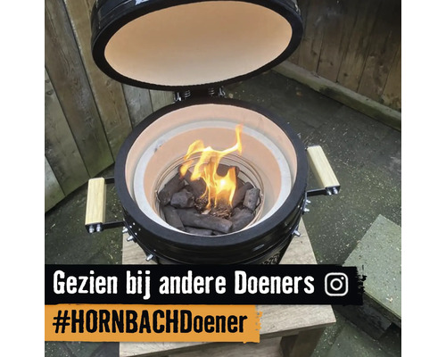 Kamado keramische barbecue met open deksel en brandende houtskool op een houten tafel. Instagram Logo. Gezien bij andere Doeners. HORNBACH Doener.