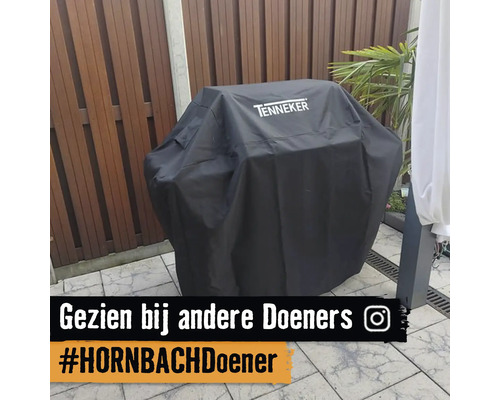 Tenneker barbecuehoes met Tenneker Logo op een barbecue op een terras met houten schutting.