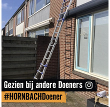 Aluminium multifunctionele ladder leunt tegen een gevel van bakstenen naast een raam van een huis.
