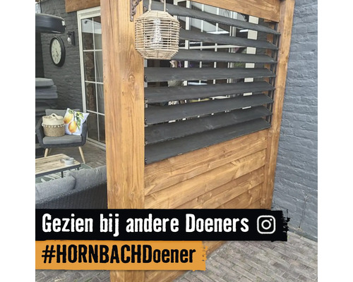 Houten tuinscherm met donkere horizontale lamellen en houten frame op een terras met tuinmeubelen.