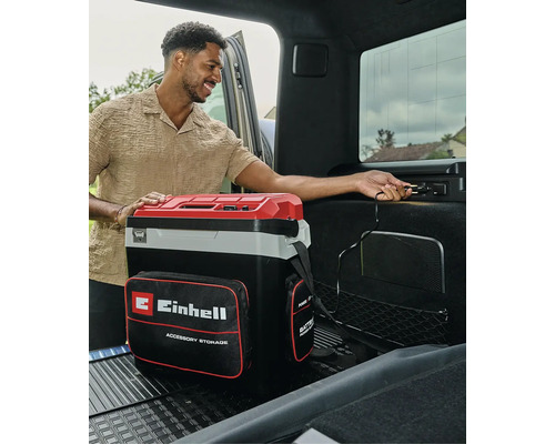 Draagbare Einhell koelbox met opbergvak, aangesloten op een 12-volt aansluiting in de kofferbak van een auto.