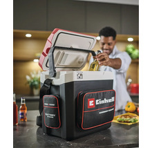 Einhell Power X-Change accu koelbox met opbergvakken in een keuken, een man haalt een flesje drinken uit de geopende koelbox.