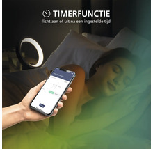 Timerfunctie voor slimme verlichting, bediend via een app op een smartphone, met een slapend persoon en een brandende nachtlamp.