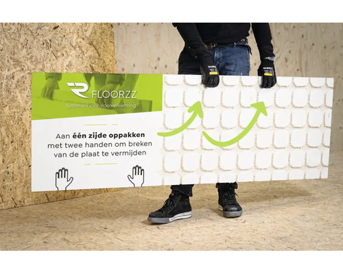 Een persoon tilt een Floorzz vloerverwarmingsplaat aan één zijde op met twee handen om breken te voorkomen. Floorzz Logo.