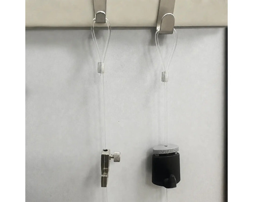 Twee schilderijophangsystemen met doorzichtige koorden aan metalen haken bevestigd voor wandmontage van lijsten.