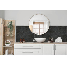 Moderne badkamer met wastafelmeubel, witte opzetwastafel, ronde spiegel en donkere wandbekleding met steenlook als spatwand.