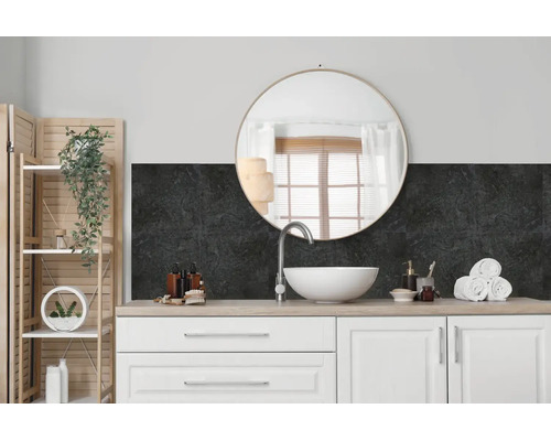 Moderne badkamer met wastafelmeubel, witte opzetwastafel, ronde spiegel en donkere wandbekleding met steenlook als spatwand.