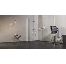 Moderne badkamer met inloopdouche van glas, betegelde muren, handdoekrek en twee hanglampen in een minimalistisch ontwerp.