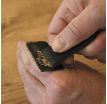 Een persoon gebruikt een speciale handschaaf voor het handmatig bewerken en verwijderen van houtoppervlakken.