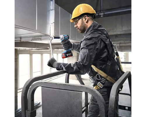 Vakman met veiligheidshelm en harnas gebruikt een Bosch accu slagschroevendraaier voor het monteren van metalen ventilatiekanalen op een hoogwerker.