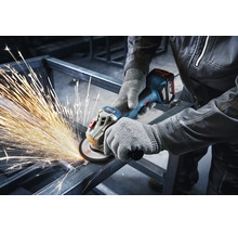 Vakman met werkhandschoenen gebruikt een Bosch accu haakse slijper voor het slijpen van een metalen frame met vonkenregen.
