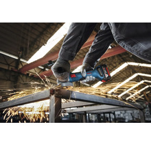 Een vakman in een werkplaats gebruikt een Bosch Professional accu haakse slijper voor het doorslijpen van metalen profielen met vonkvorming.