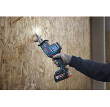 Een persoon gebruikt een Bosch Professional accusabelzaag 18 volt om een OSB plaat te zagen.