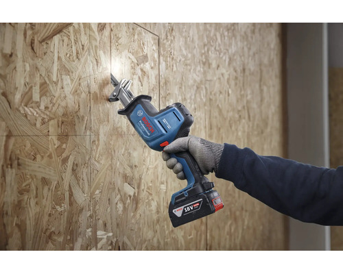 Een persoon gebruikt een Bosch Professional accusabelzaag 18 volt om een OSB plaat te zagen.