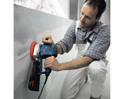 Man schuurt wand met een gipsplaats schuurmachine van Bosch