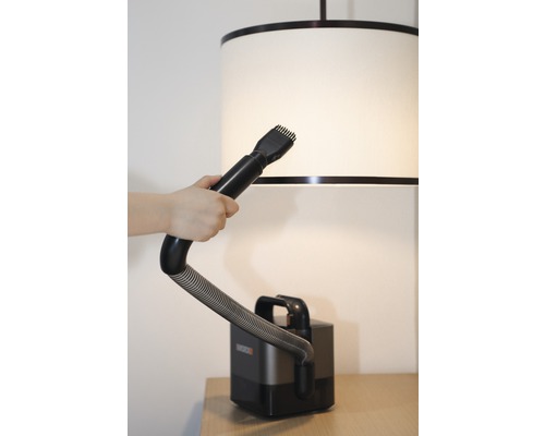 Stofzuiger met borstelopzetstuk in gebruik op een lampenkap