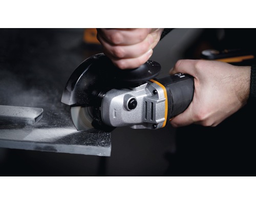 Een hand houdt een haakse slijper vast tijdens het slijpen van een stuk metaal.