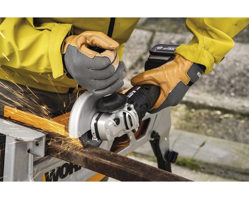 Een persoon snijdt een stuk metaal met een haakse slijper, waarbij vonken vrijkomen.