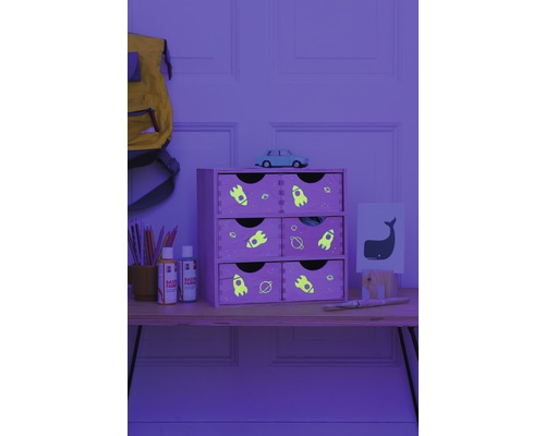 Decoratieve houten plankenkast met zes laden en ruimtemotieven op een tafel met schildersbenodigdheden