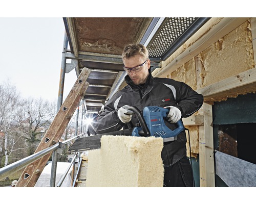 Een man snijdt isolatiemateriaal met een isolatiezaag op een steiger. Bosch Logo.