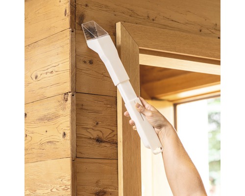 Hand die een wit stofverwijderingsapparaat op een houten frame gebruikt