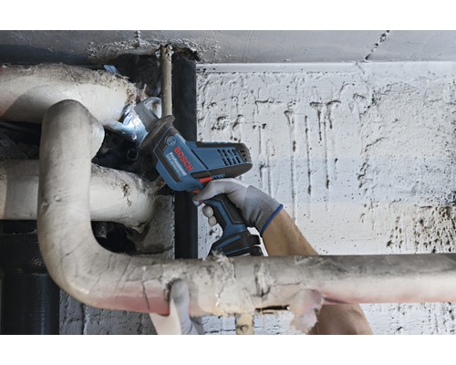 Accuzaag in gebruik op een verwarmingsbuis, bediend door iemand met handschoenen