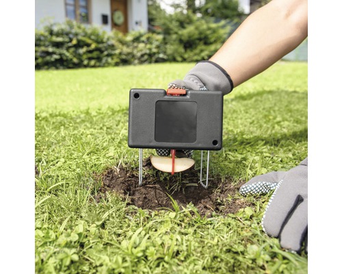 Geplaatste woelmuizenval met appelstuk als lokaas in de tuin
