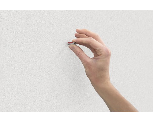Hand plaatst plug in muur