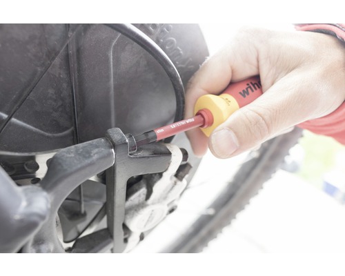 Een persoon gebruikt een schroevendraaier op een fiets.