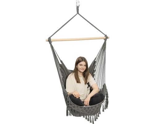 Grijze hangstoel met houten stok en zittend persoon