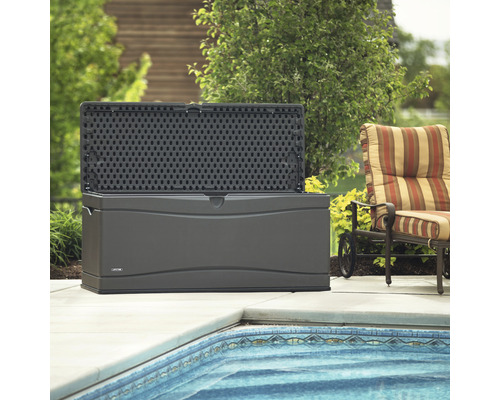 Geopende grijze tuinkist van kunststof naast zwembad en fauteuil