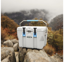 Grijze koelbox met handgreep op rotsen