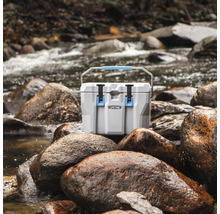 Koelbox op stenen in de buurt van een rivier