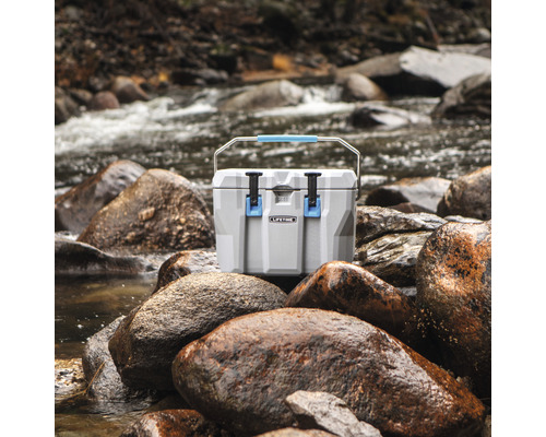 Koelbox op stenen in de buurt van een rivier