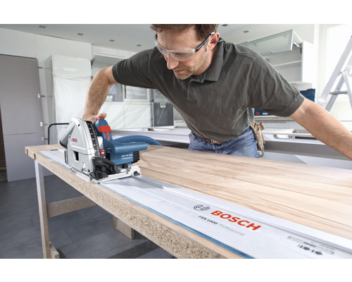 Man zaagt houten plank met een Bosch invalzaag en geleiderail.