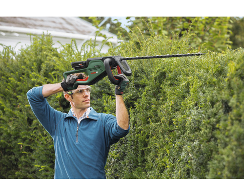 Man snoeit heg met accuheggenschaar