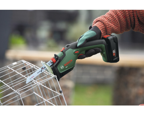 Bosch Logo. Persoon snijdt een draadmand door met een accusabelzaag