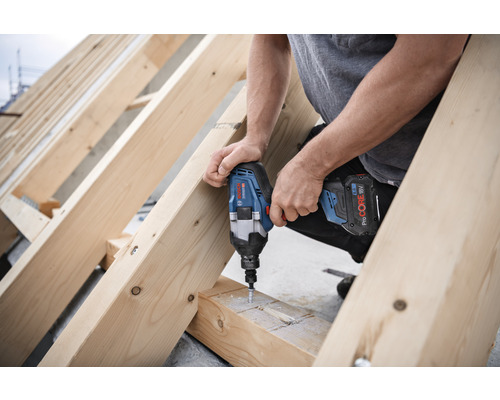 Ambachtsman schroeft met een accuslagschroevendraaier schroeven in een houten constructie.