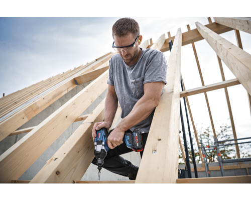 Vakman met accuslagschroevendraaier bij dakconstructie