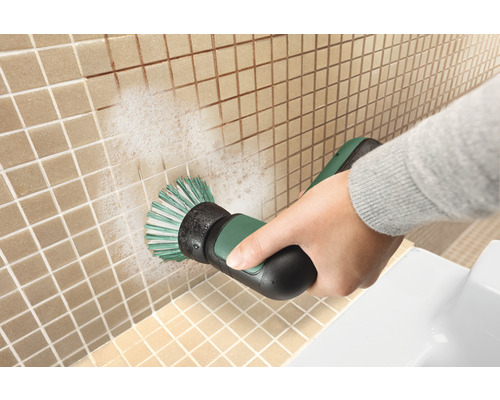 Iemand reinigt tegels met een elektrische borstel.