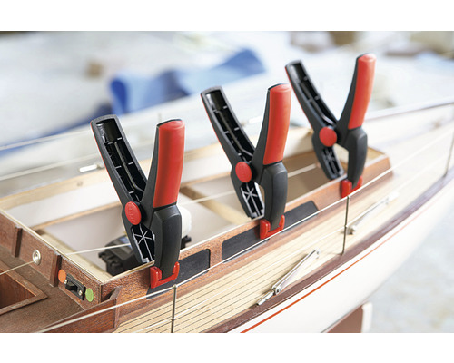 Drie veerbelaste klemmen bevestigd aan een houten modelboot