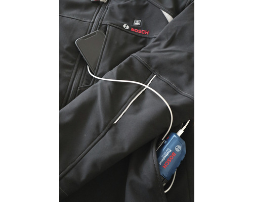 Detailopname van een zwarte Bosch werkjas met smartphone in de zak en aangesloten batterij