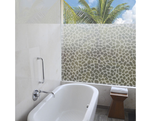 Lichte badkamer met ligbad, vensterfolie met patroon en houten kruk