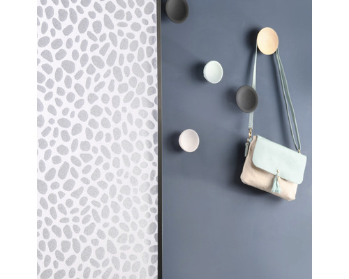 Muur met patroonbehang en ronde wandhaken met handtas