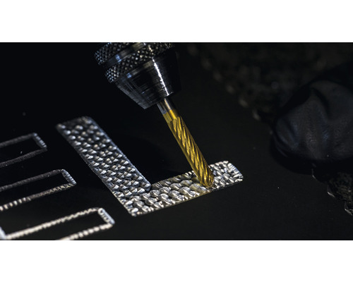 Een frees graveert een ontwerp in een materiaal.