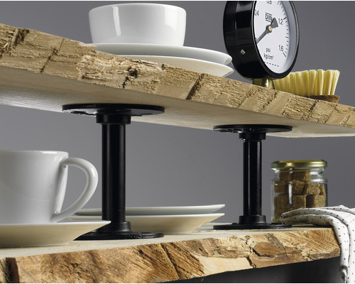 Rustieke plank met houten planken en zwarte metalen steunen, versierd met serviesgoed en een manometer.
